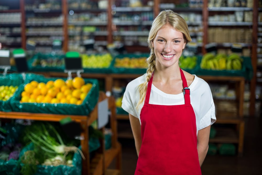 Portrait of smiling female staff standing in organic section of supermarket