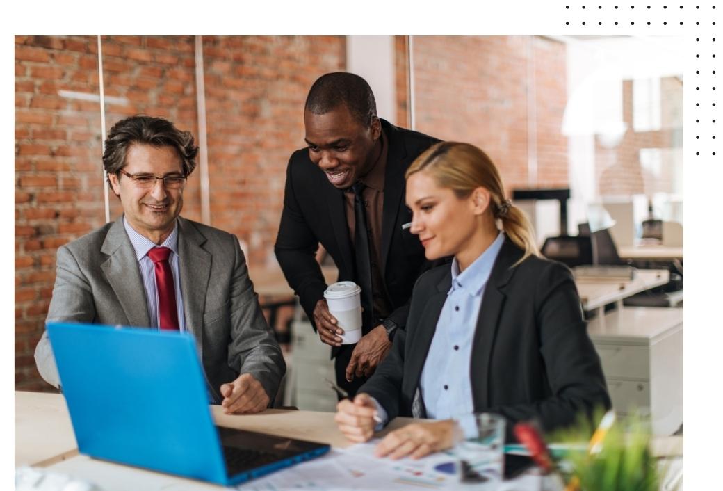 two men and a woman in business attire looking at a laptop together